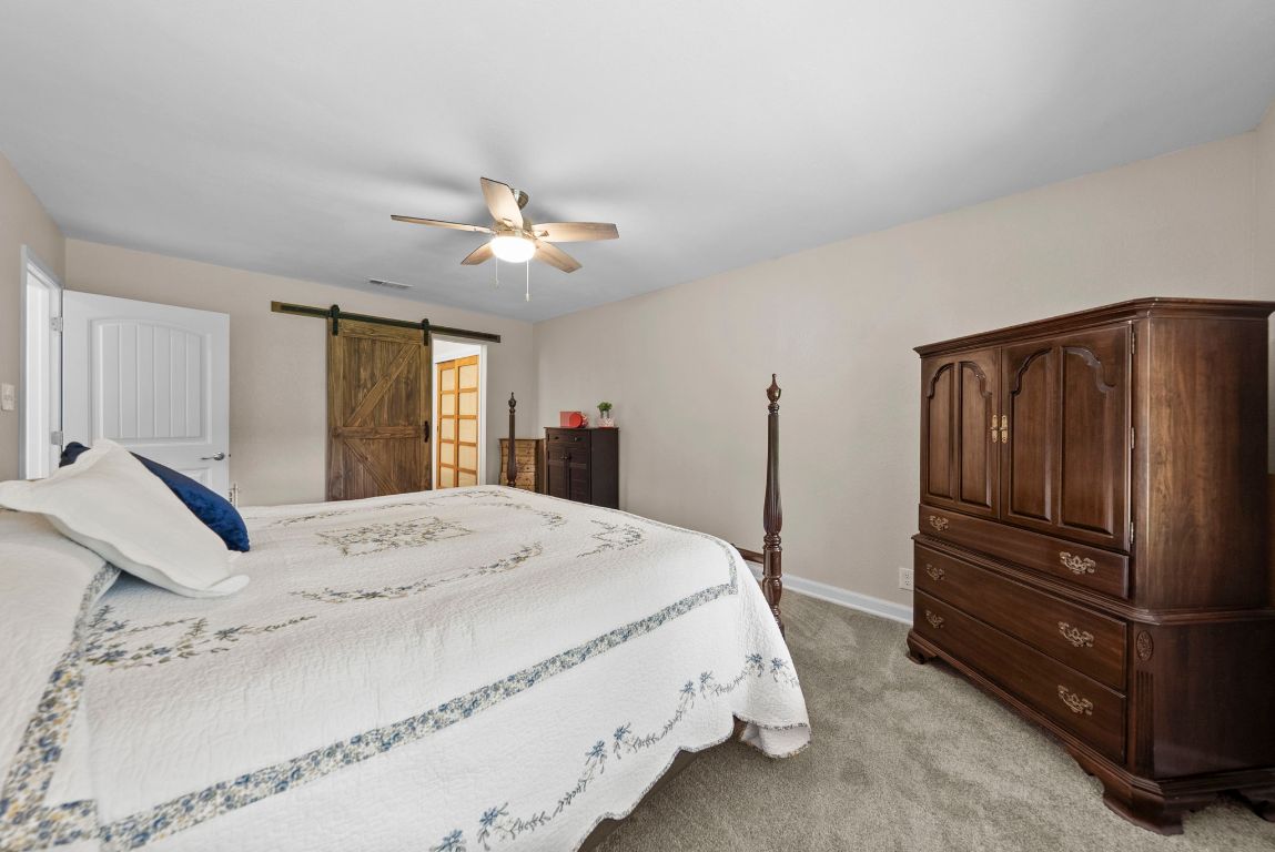 2702 Double Tree Street Round Rock, TX 78681 - Photo 20 of 35 a spacious bedroom with a bed and a chandelier