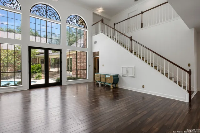 a view of hall with wooden floor and a front door