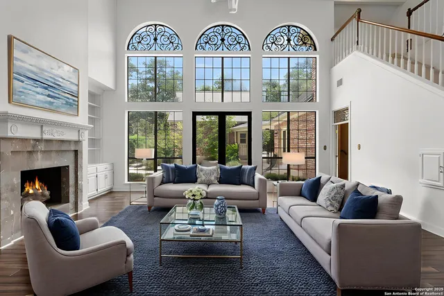 a living room with furniture a fireplace a large window and a flat tv screen