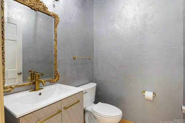 a bathroom with a sink a toilet and mirror