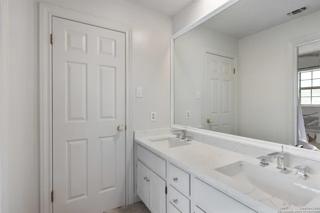 a bathroom with 2 sink and a mirror