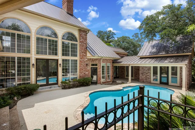 a front view of a house with patio furniture and tables