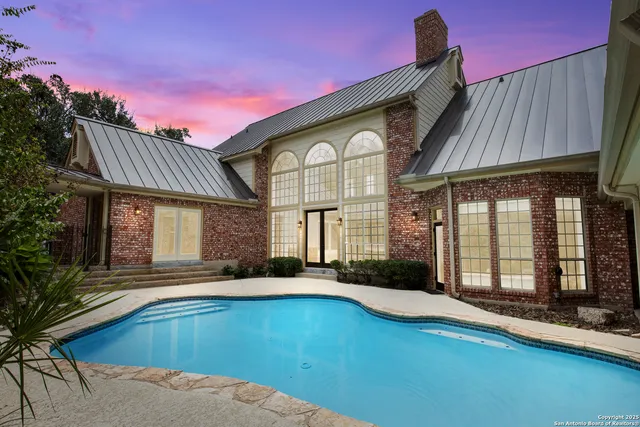 a front view of a house with swimming pool having outdoor seating