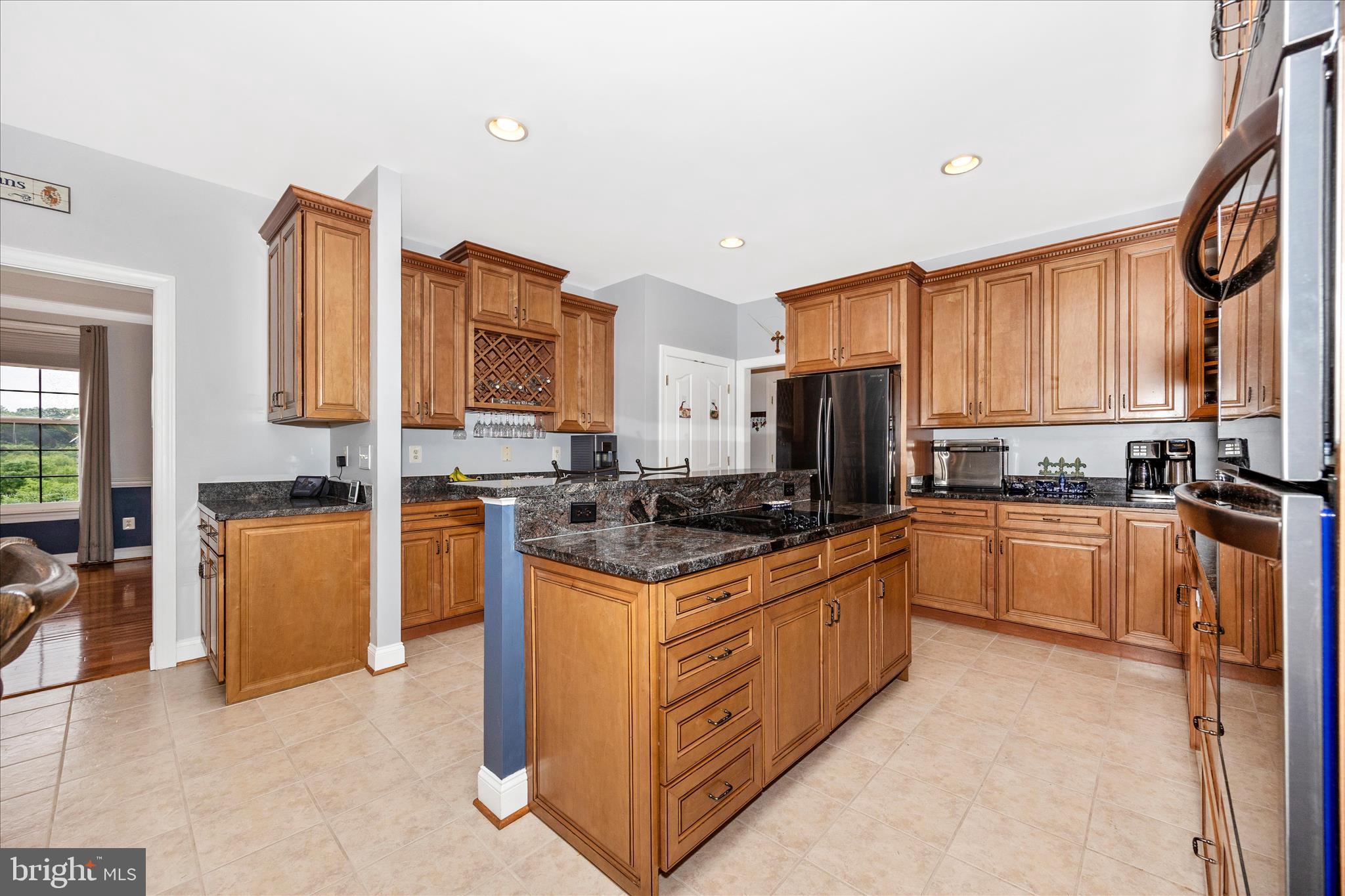 9855 McKinstry Mill Road New Windsor, MD 21776 - Photo 13 of 76 a kitchen with stainless steel appliances granite countertop a stove top oven a sink dishwasher a refrigerator and a dining table with granite countertops