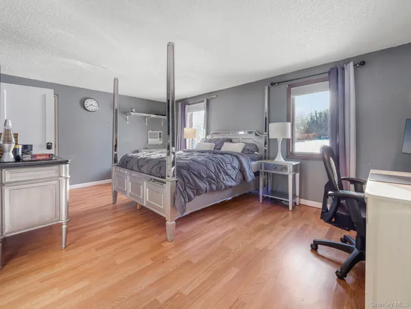 a bedroom with a bed a table and wooden floor