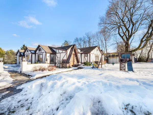 a view of a white house with a yard covered with snow