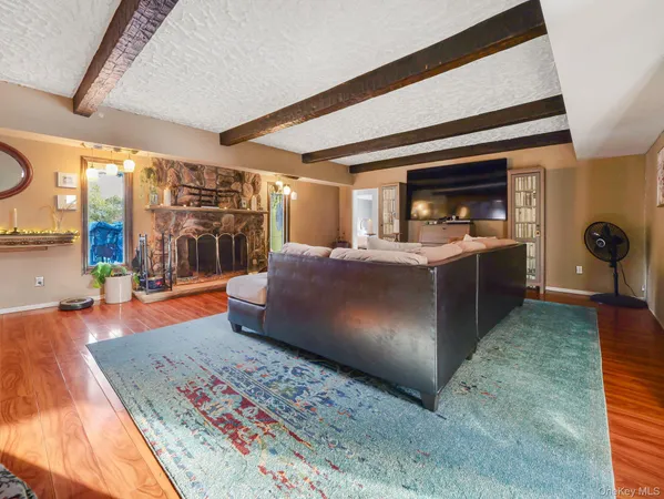 a living room with stainless steel appliances kitchen island granite countertop a refrigerator a stove a sink and a dining table with wooden floor