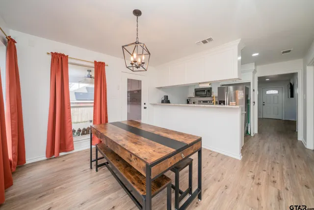 a living room with stainless steel appliances kitchen island granite countertop furniture and wooden floor