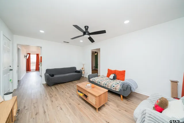 a living room with furniture and a wooden floor