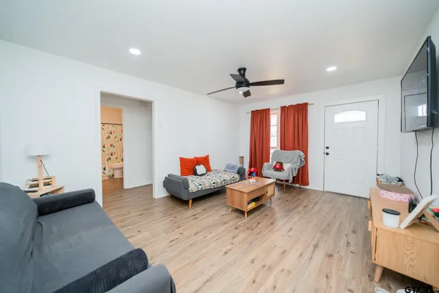 a living room with furniture and a wooden floor