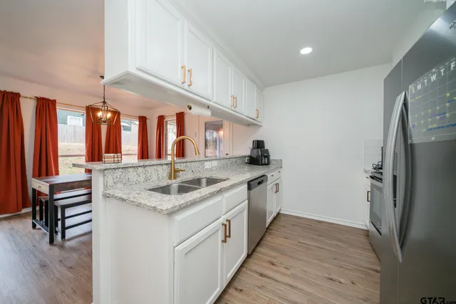 a kitchen with stainless steel appliances granite countertop a sink and a refrigerator