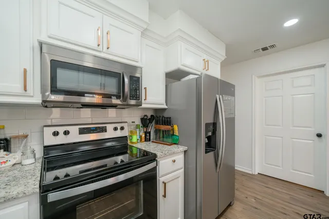 a kitchen with stainless steel appliances a refrigerator stove and microwave
