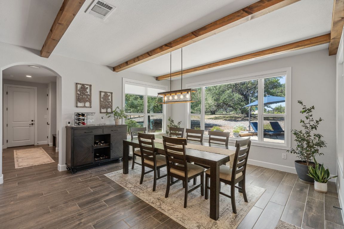 291 Southwick Ranch Road Johnson City, TX 78636 - Photo 15 of 40 Dining room featuring beamed ceiling, wood tile floors, and arched walkways
