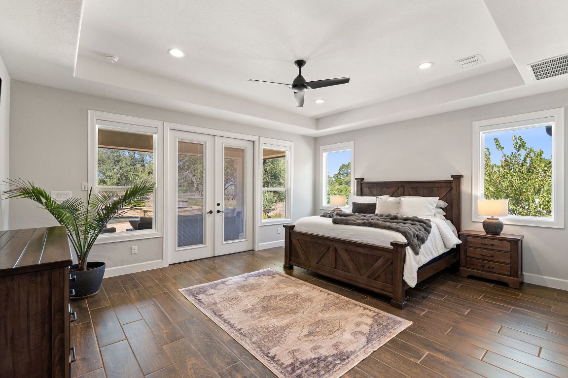 291 Southwick Ranch Road Johnson City, TX 78636 - Photo 16 of 40 Bedroom featuring a raised ceiling, ceiling fan, multiple windows, and recessed lighting