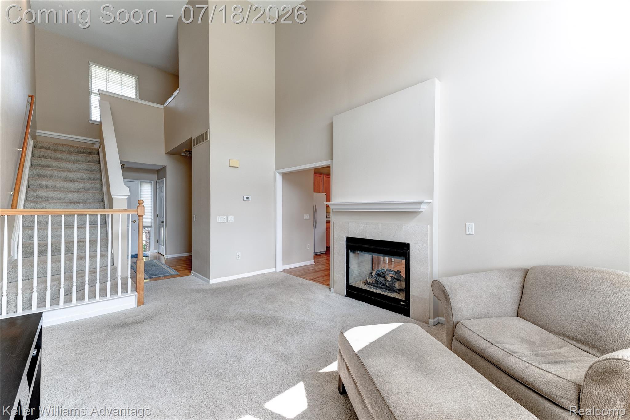 41647 Mitchell Road Novi, MI 48377 - Photo 14 of 43 Two-story living area with neutral carpeting and a fireplace featuring a tile surround and white mantel
