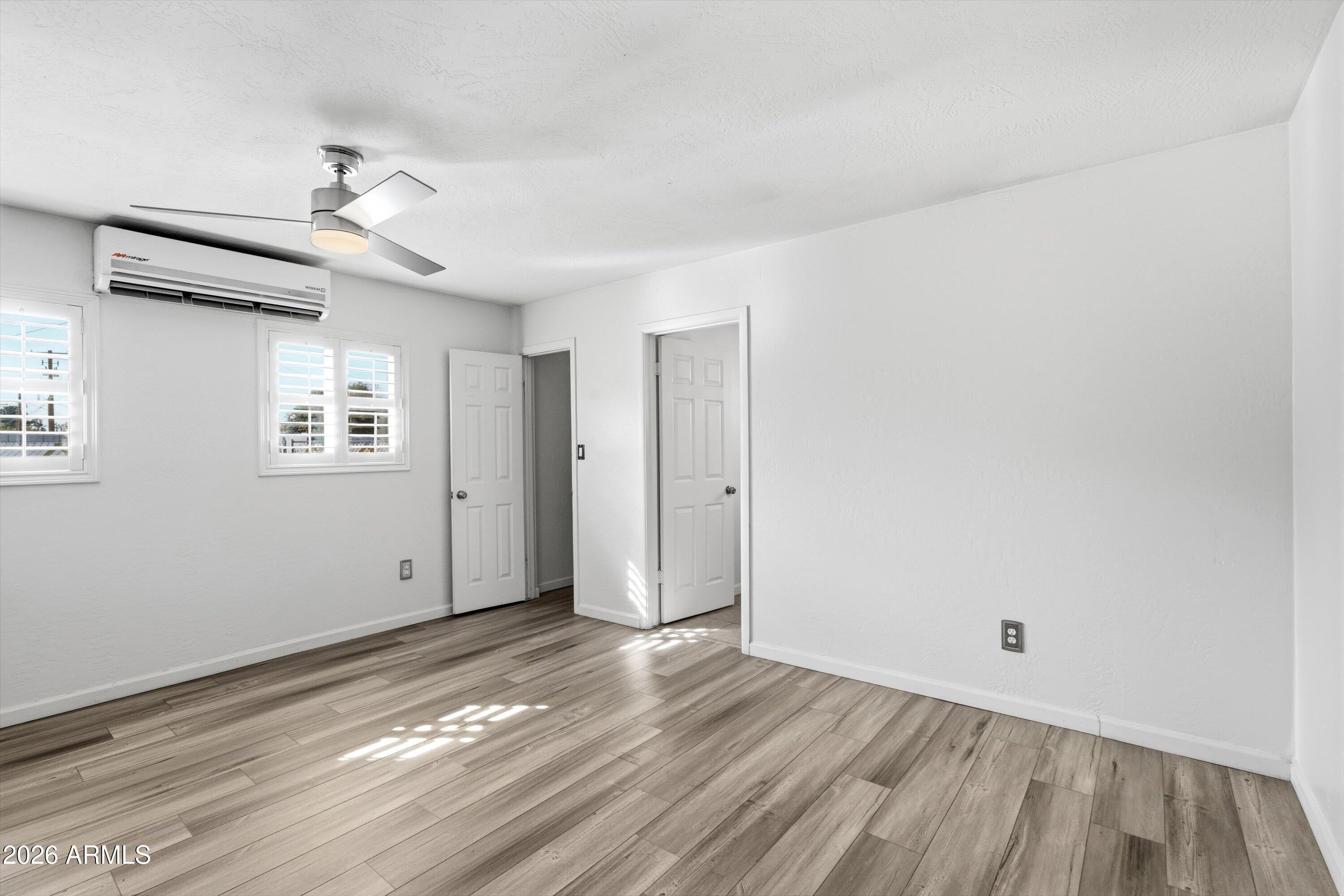 6246 North 23rd Avenue Phoenix, AZ 85015 - Photo 14 of 30 a view of an empty room with wooden floor and a window