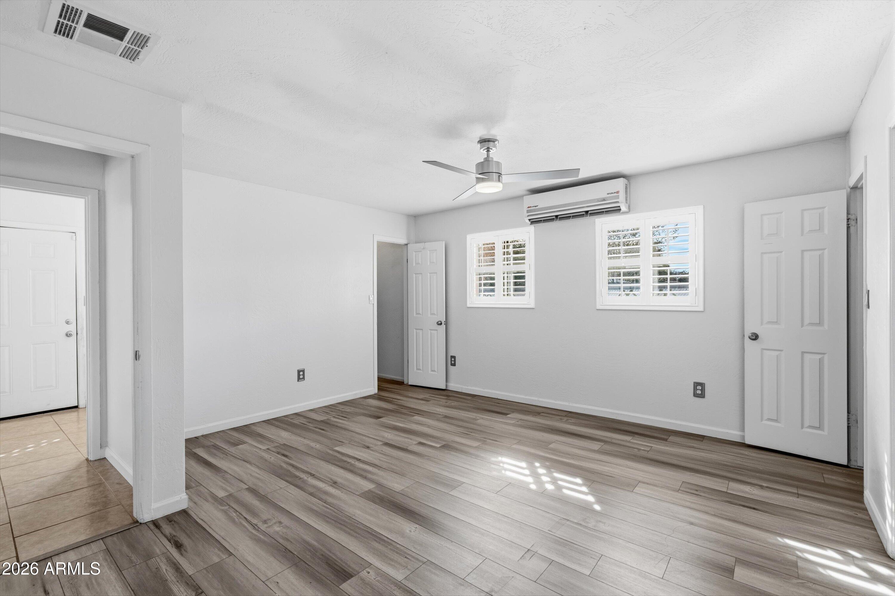 6246 North 23rd Avenue Phoenix, AZ 85015 - Photo 15 of 30 a view of empty room with wooden floor and fan
