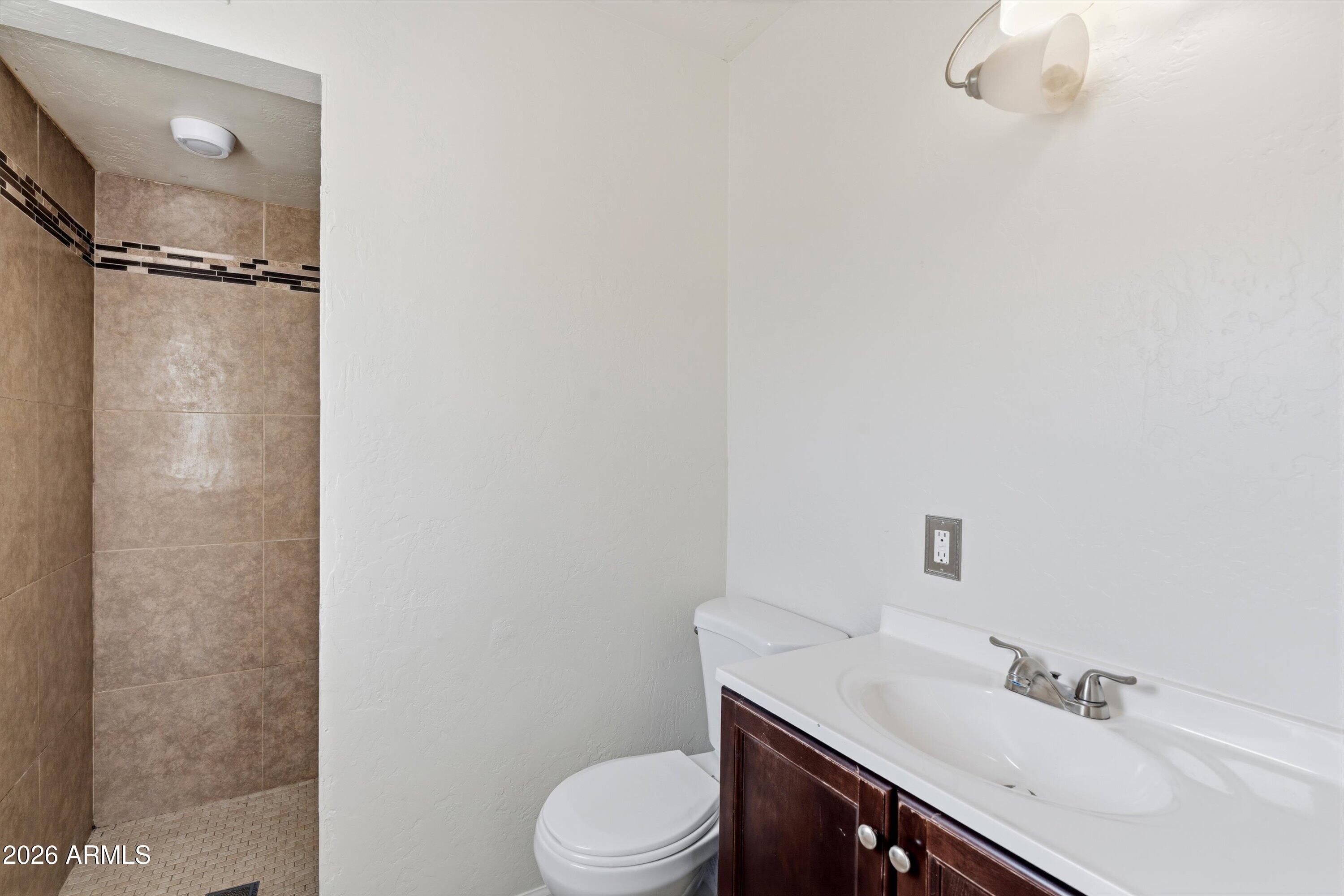 6246 North 23rd Avenue Phoenix, AZ 85015 - Photo 21 of 30 a bathroom with a sink vanity mirror and toilet