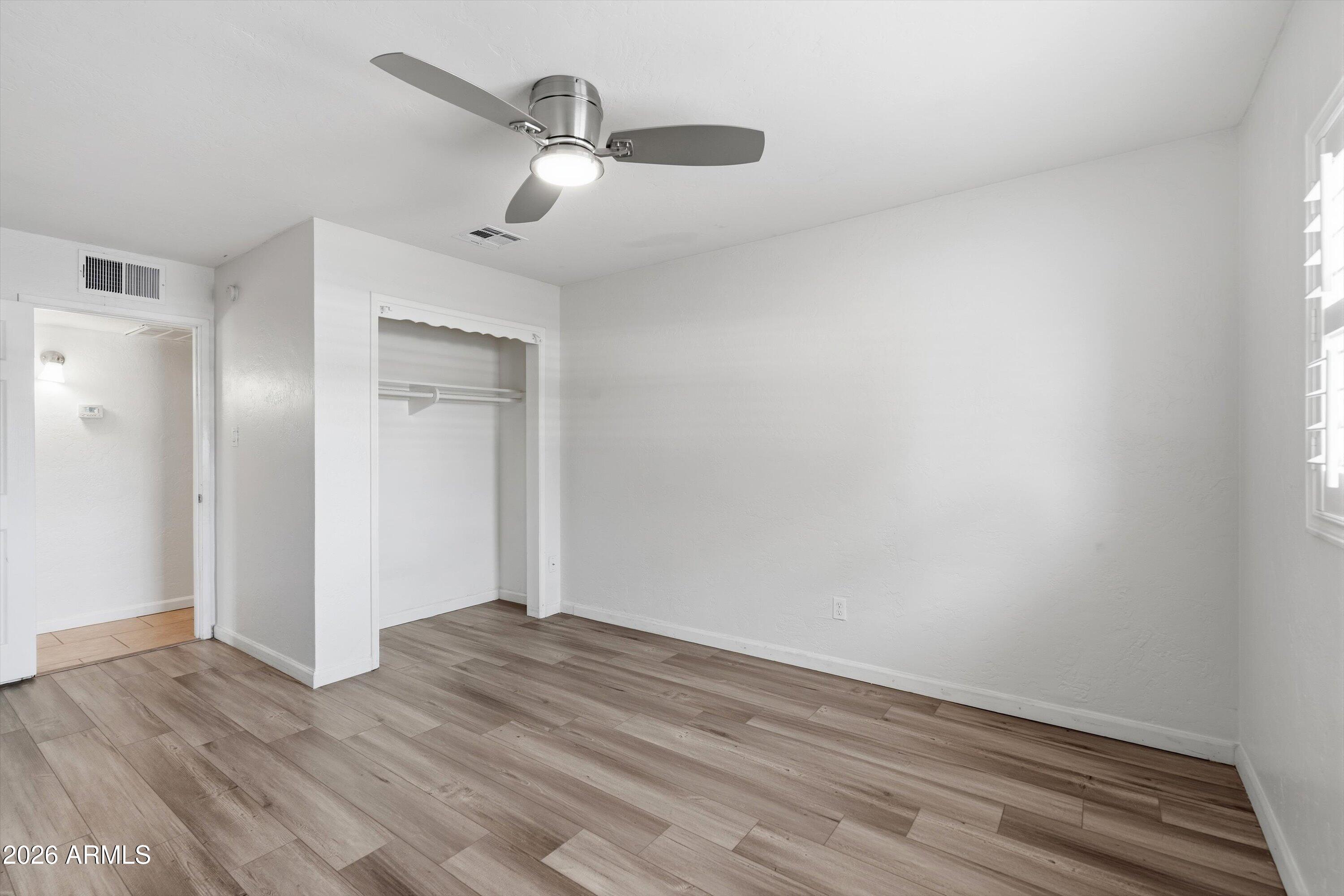 6246 North 23rd Avenue Phoenix, AZ 85015 - Photo 23 of 30 a view of an empty room with wooden floor
