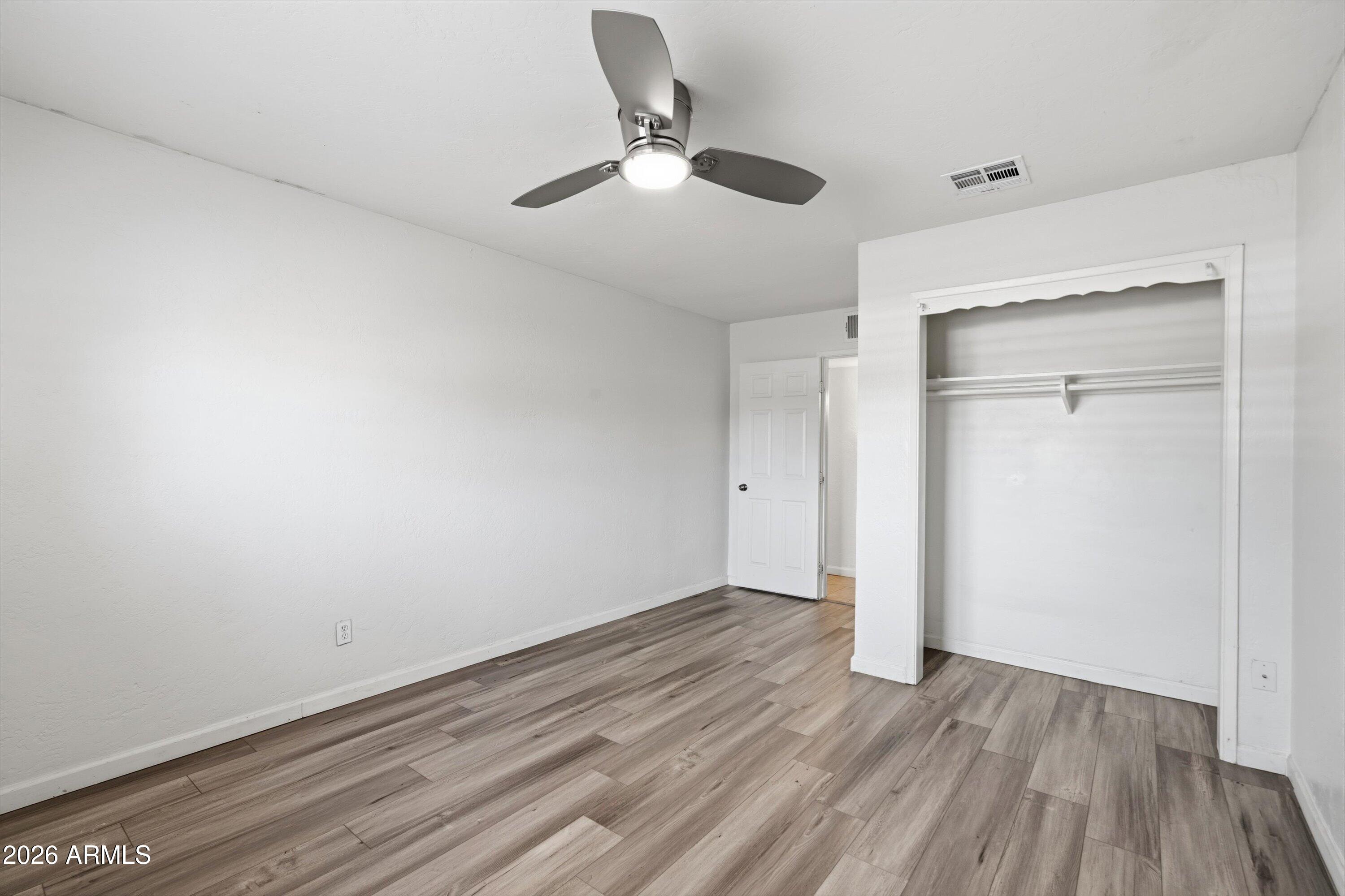 6246 North 23rd Avenue Phoenix, AZ 85015 - Photo 24 of 30 a view of an empty room with wooden floor
