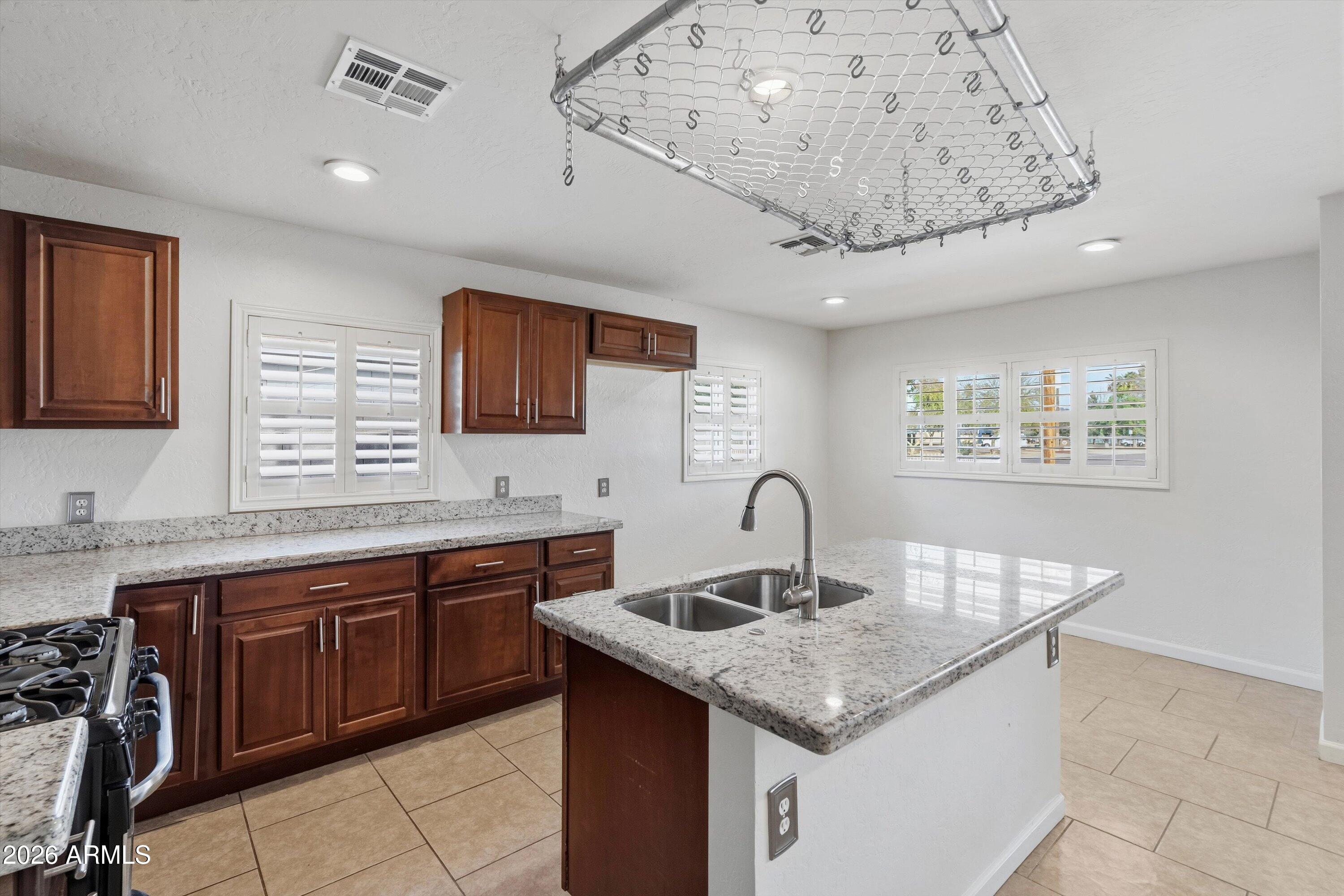 6246 North 23rd Avenue Phoenix, AZ 85015 - Photo 4 of 30 a kitchen with a sink a counter space and cabinets