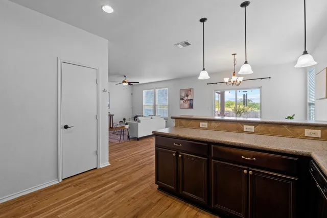a kitchen with stainless steel appliances granite countertop a sink a counter space and wooden floor