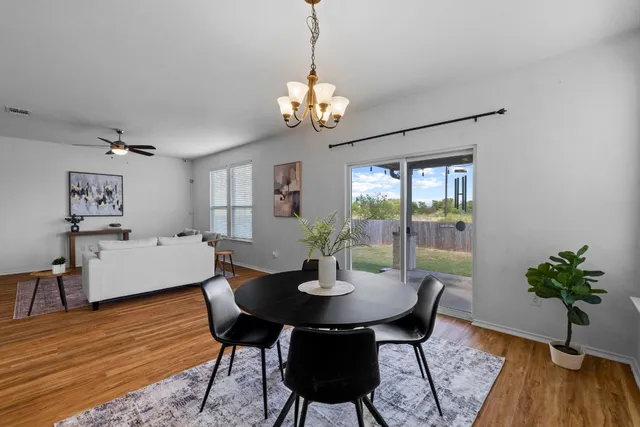 a dining room with furniture potted plants and wooden floor