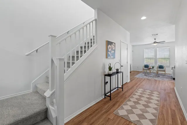 a view of a hallway with wooden floor and staircase