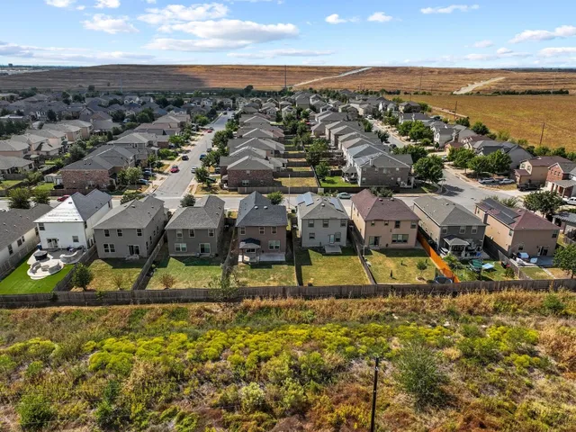 an aerial view of residential houses with outdoor space and ocean view