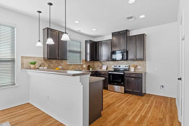 a kitchen with kitchen island granite countertop wooden cabinets and stainless steel appliances