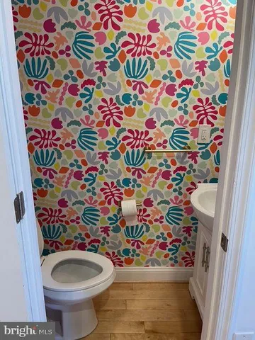 a bedroom with a bed wooden floor and a mirror