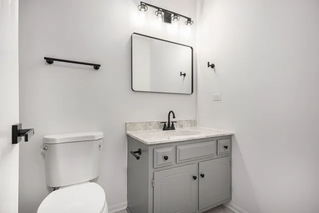a bathroom with a toilet a sink and mirror