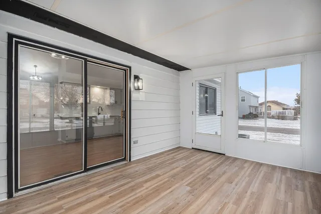 a view of a big room with wooden floor and windows