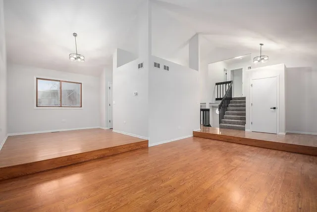 a view of empty room with wooden floor