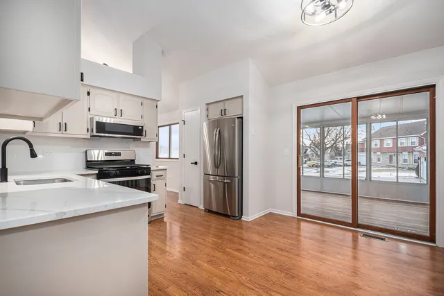 a kitchen with granite countertop a refrigerator stove top oven and sink