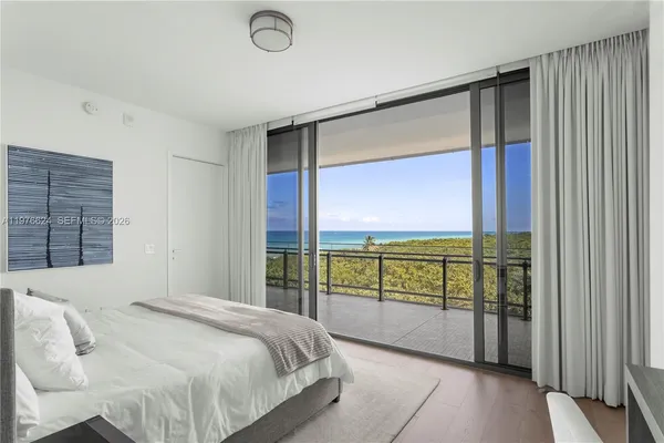 a bedroom with a large window and a balcony