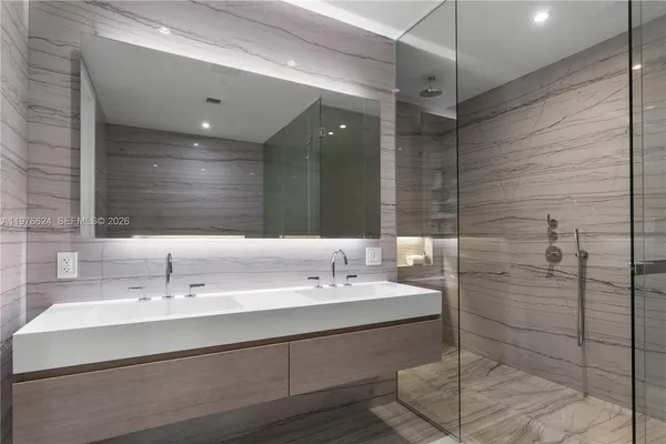 a bathroom with a double vanity sink mirror and shower