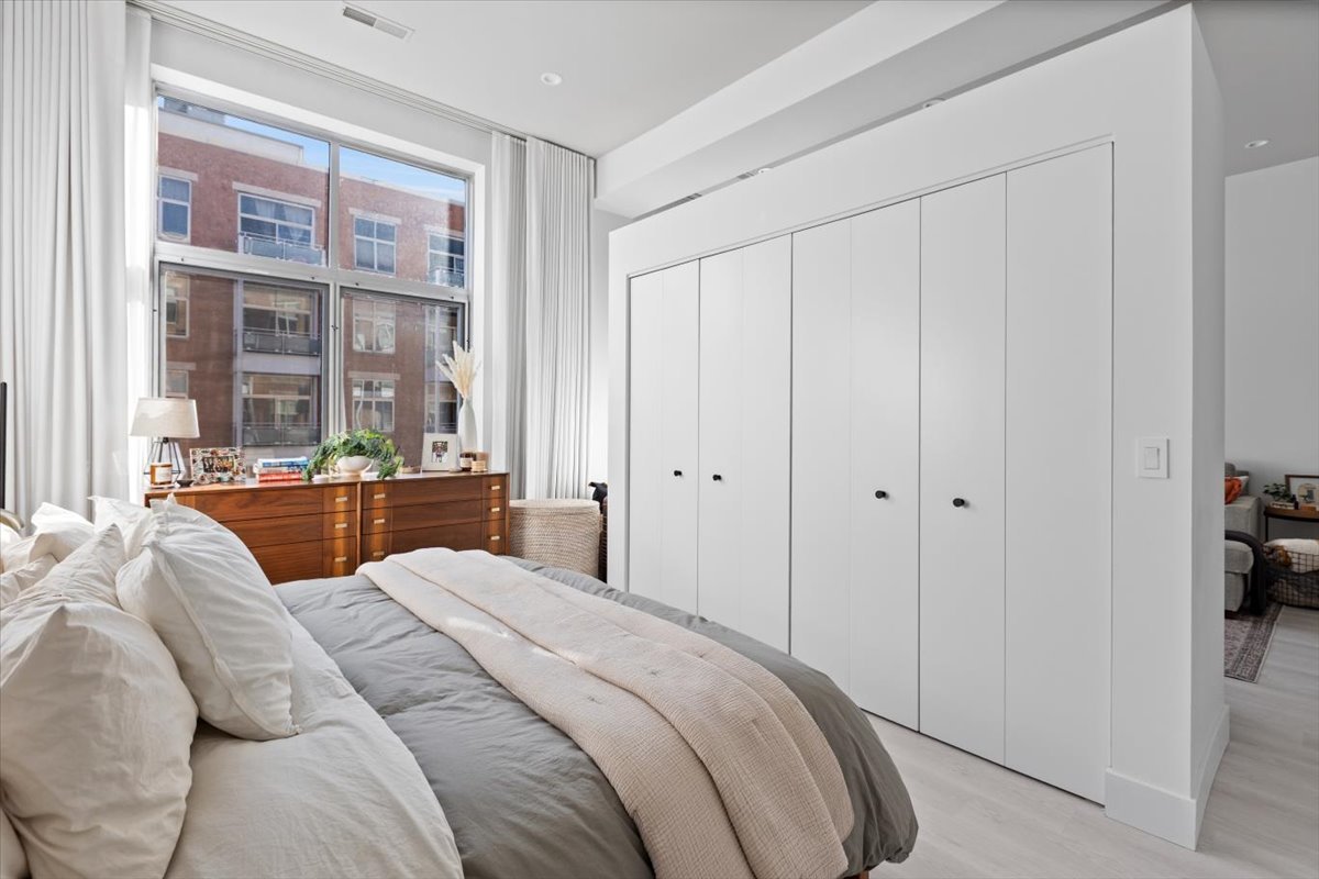 949 West Madison Street, Unit 406 Chicago, IL 60607 - Photo 11 of 16 a bedroom with a bed and a large window