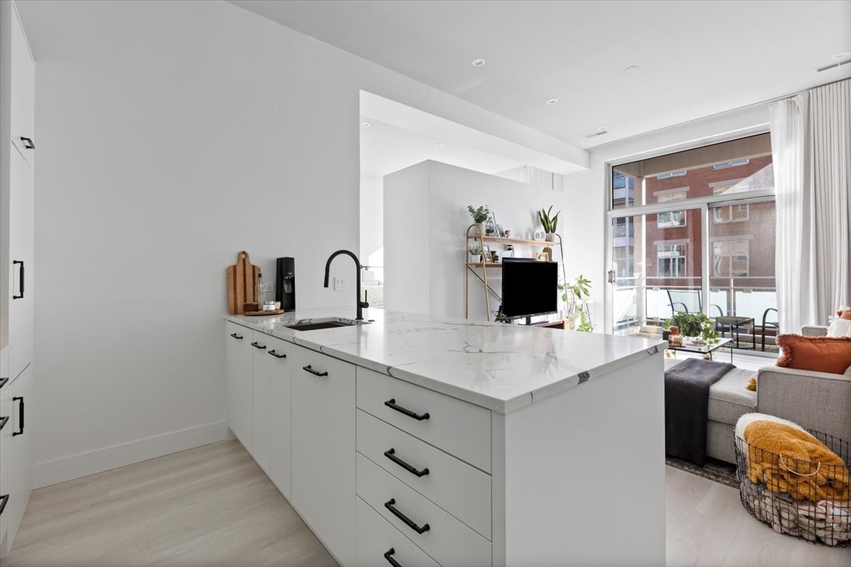 949 West Madison Street, Unit 406 Chicago, IL 60607 - Photo 6 of 16 a large white kitchen with a sink and dishwasher a stove with wooden floor