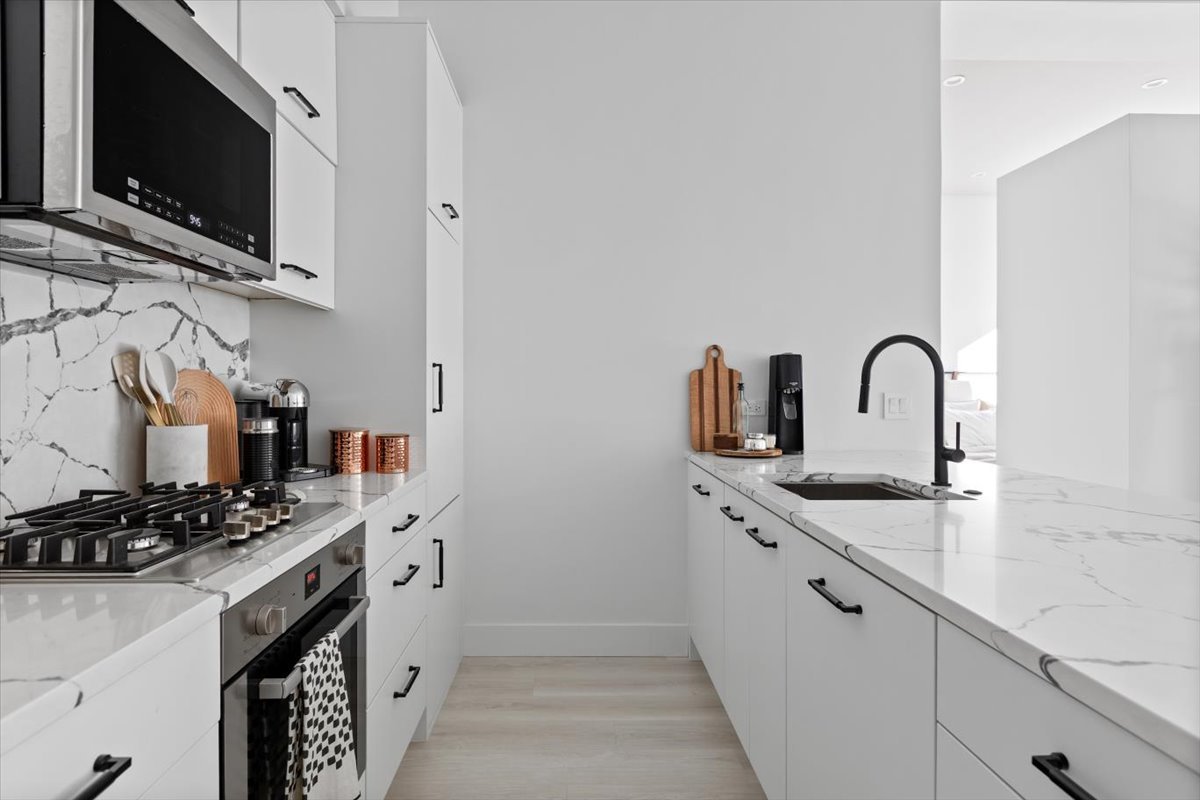 949 West Madison Street, Unit 406 Chicago, IL 60607 - Photo 7 of 16 a kitchen with stainless steel appliances granite countertop a sink a stove and a microwave