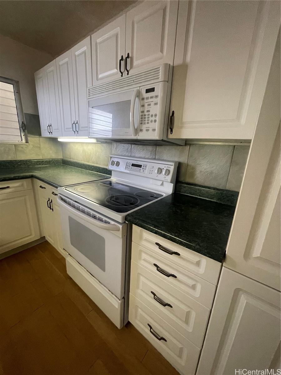 469 Ena Road, Unit 2102 Honolulu, HI 96815 - Photo 9 of 15 a kitchen with granite countertop white cabinets and white appliances