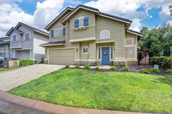 a front view of a house with a garden