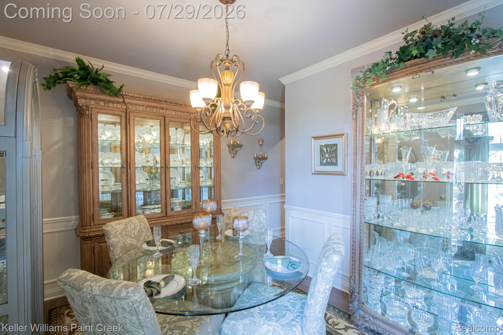 49118 Ridgeview Drive Macomb, MI 48044 - Photo 12 of 57 Dining area featuring a glass-top dining table, ornate chandelier, decorative wall sconces, and crown molding