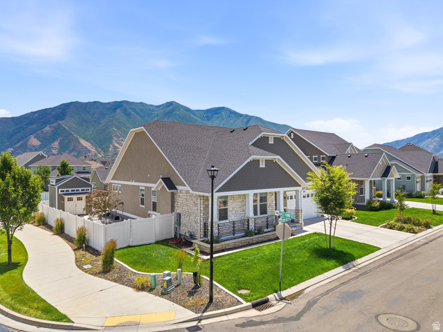 877 South Yarrow Drive Mapleton, UT 84664 - Photo 43 of 46 Contemporary residence featuring a stone and siding exterior, an attached two-car garage, and a covered front porch with railing