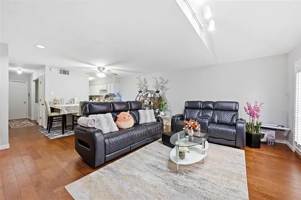 a living room with furniture and a wooden floor