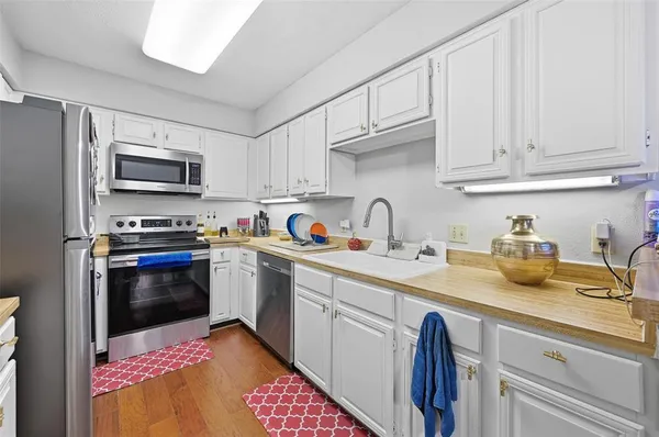a kitchen with sink cabinets and stainless steel appliances