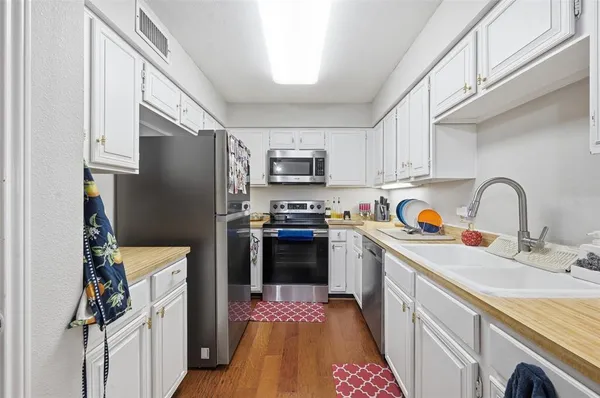 a kitchen with stainless steel appliances granite countertop a refrigerator stove and sink