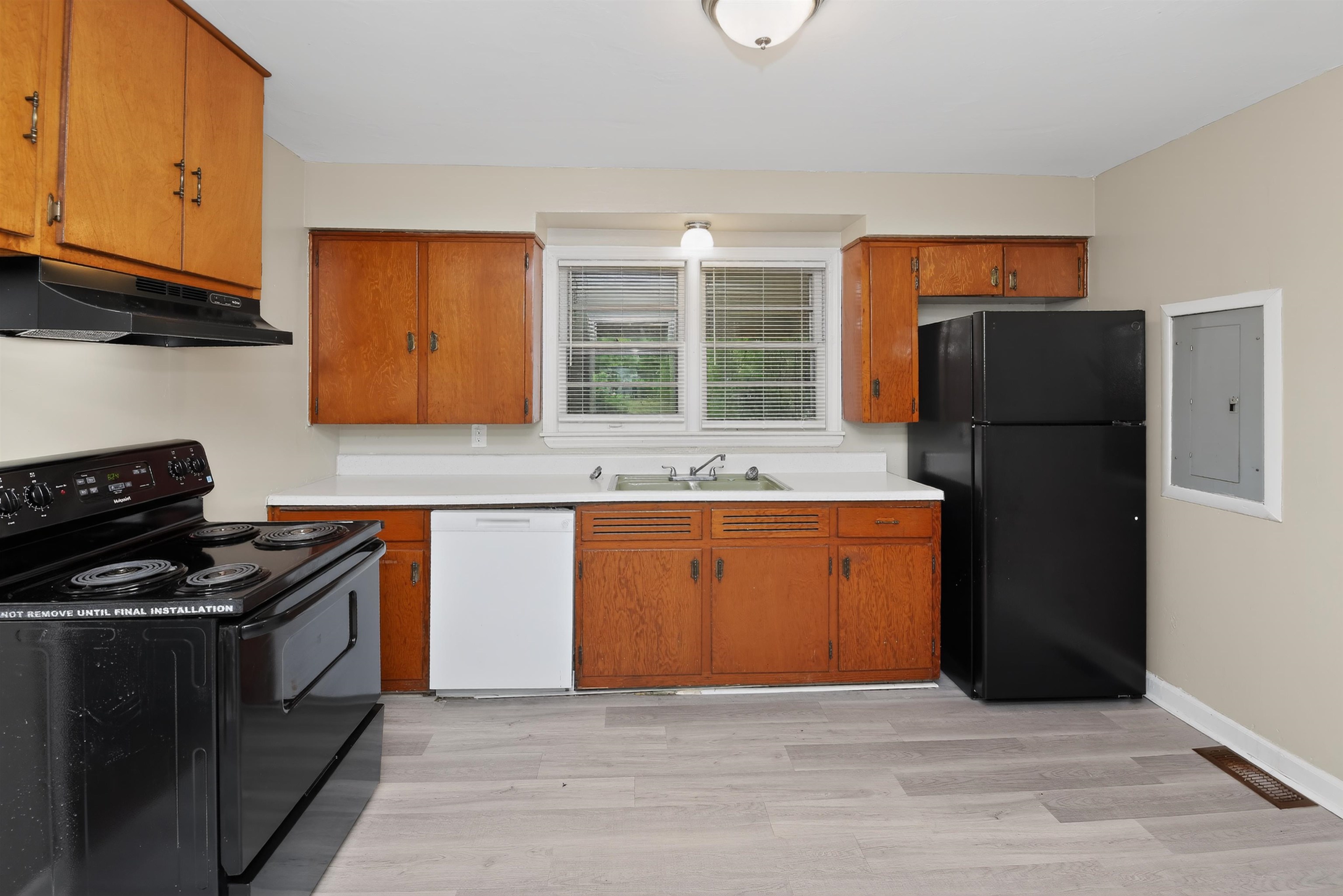 2840 Allen Road Memphis, TN 38128 - Photo 23 of 31 Kitchen featuring wood cabinetry, white countertops, a double-basin sink, a window, and wood-finish flooring