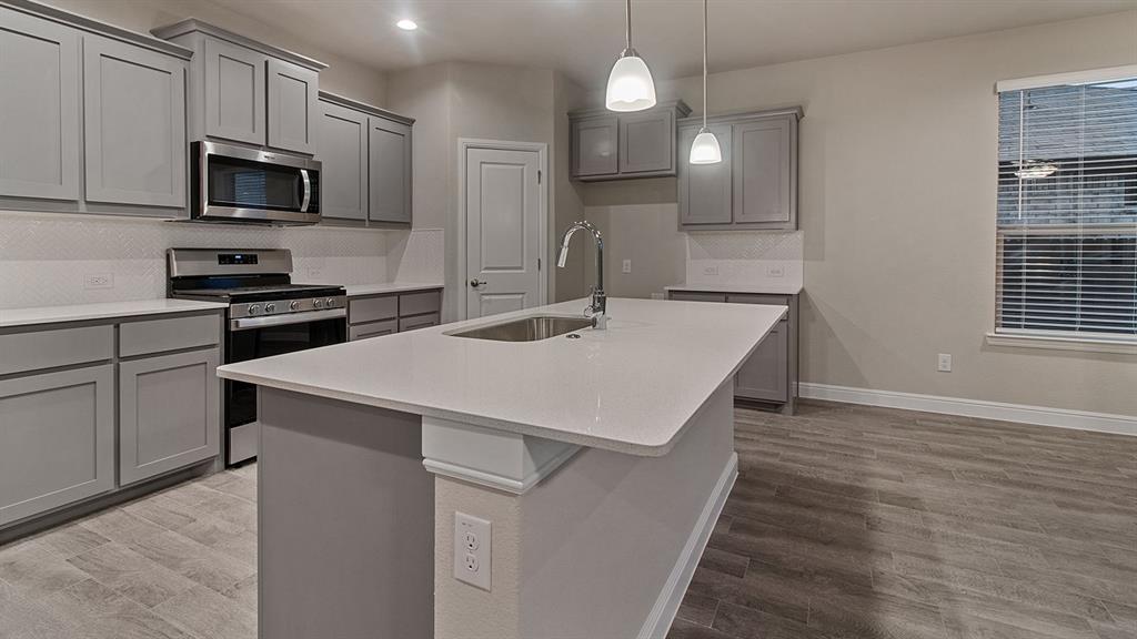 110 Castell Avenue Rhome, TX 76078 - Photo 27 of 29 a kitchen that has a microwave a sink and a stove in it