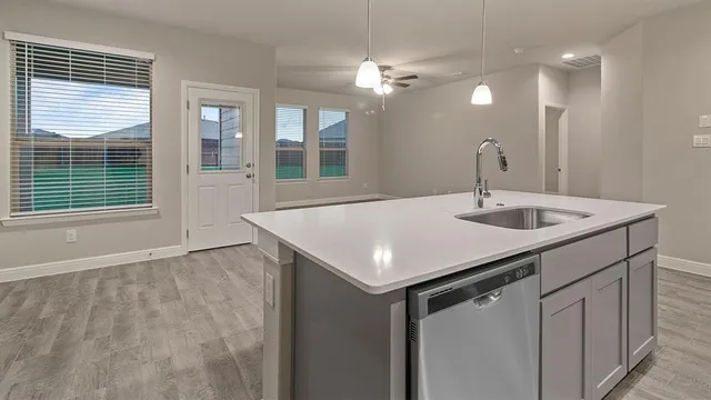 a kitchen with stainless steel appliances a stove microwave and sink